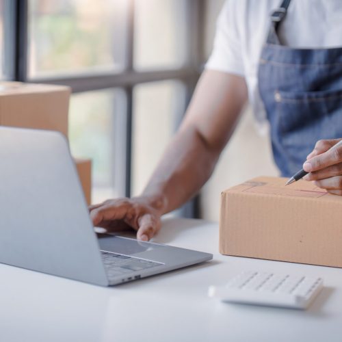 Online shopping young start small business in a cardboard box at work. The seller prepares the delivery box for the customer, online sales, or ecommerce